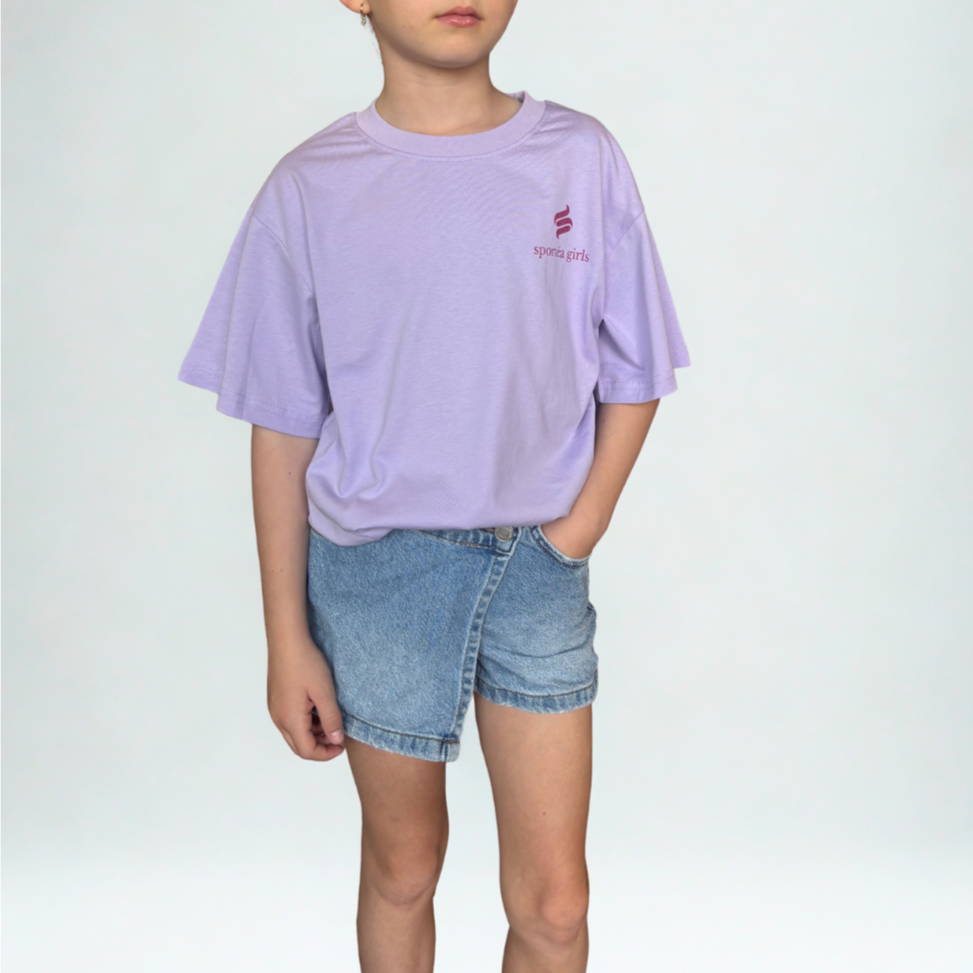 Child wearing a light purple t-shirt and denim shorts on a white background