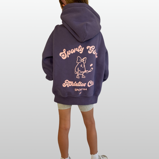 Person wearing a purple hoodie with text and graphics on the back, standing against a white background