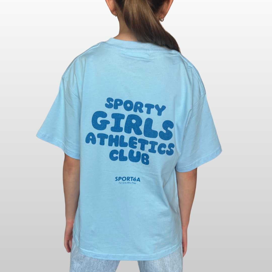 Light blue t-shirt with 'Sporty Girls Athletics Club' text on the back, worn by a person.