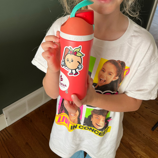 Child holding a red cup with a cartoon character on a white wall background
